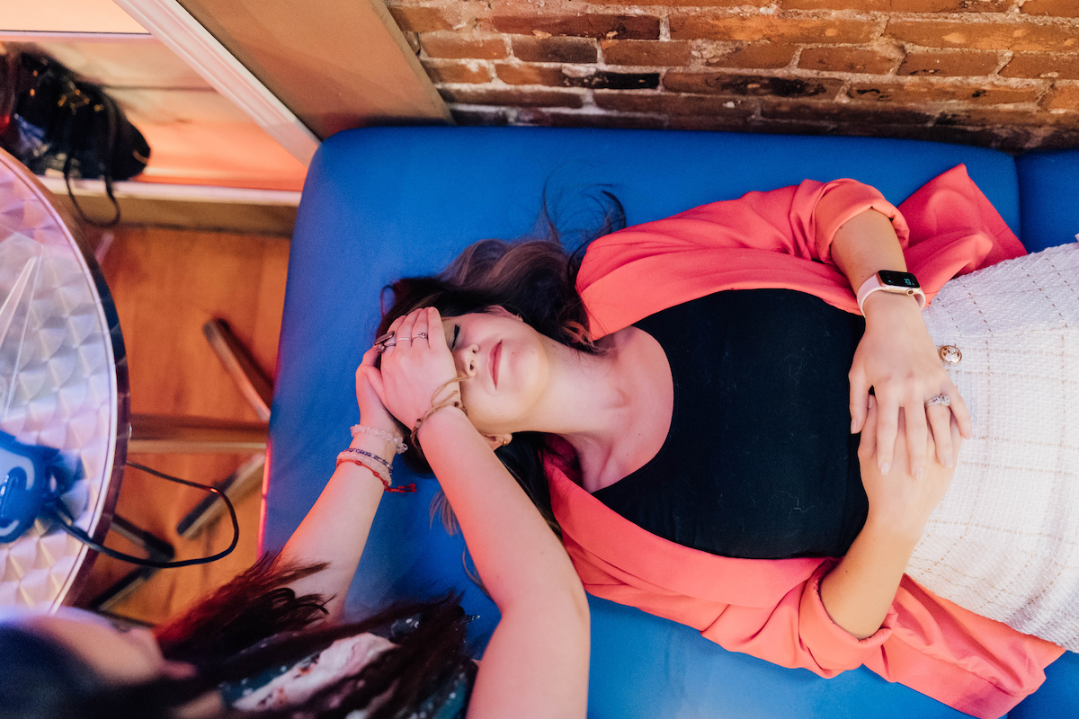 Image shows a woman receiving a Reiki session.