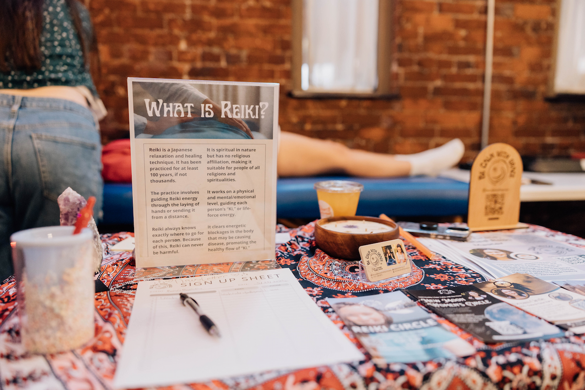 Image shows a sign that says "What is Reiki?" on a decorative table.