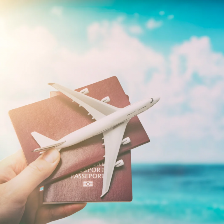 Image shows a hand holding an airplane and passports.